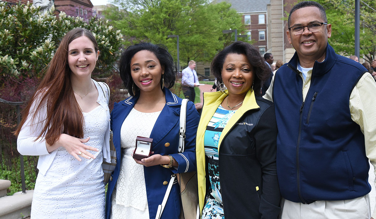 Students posing with rings and parents